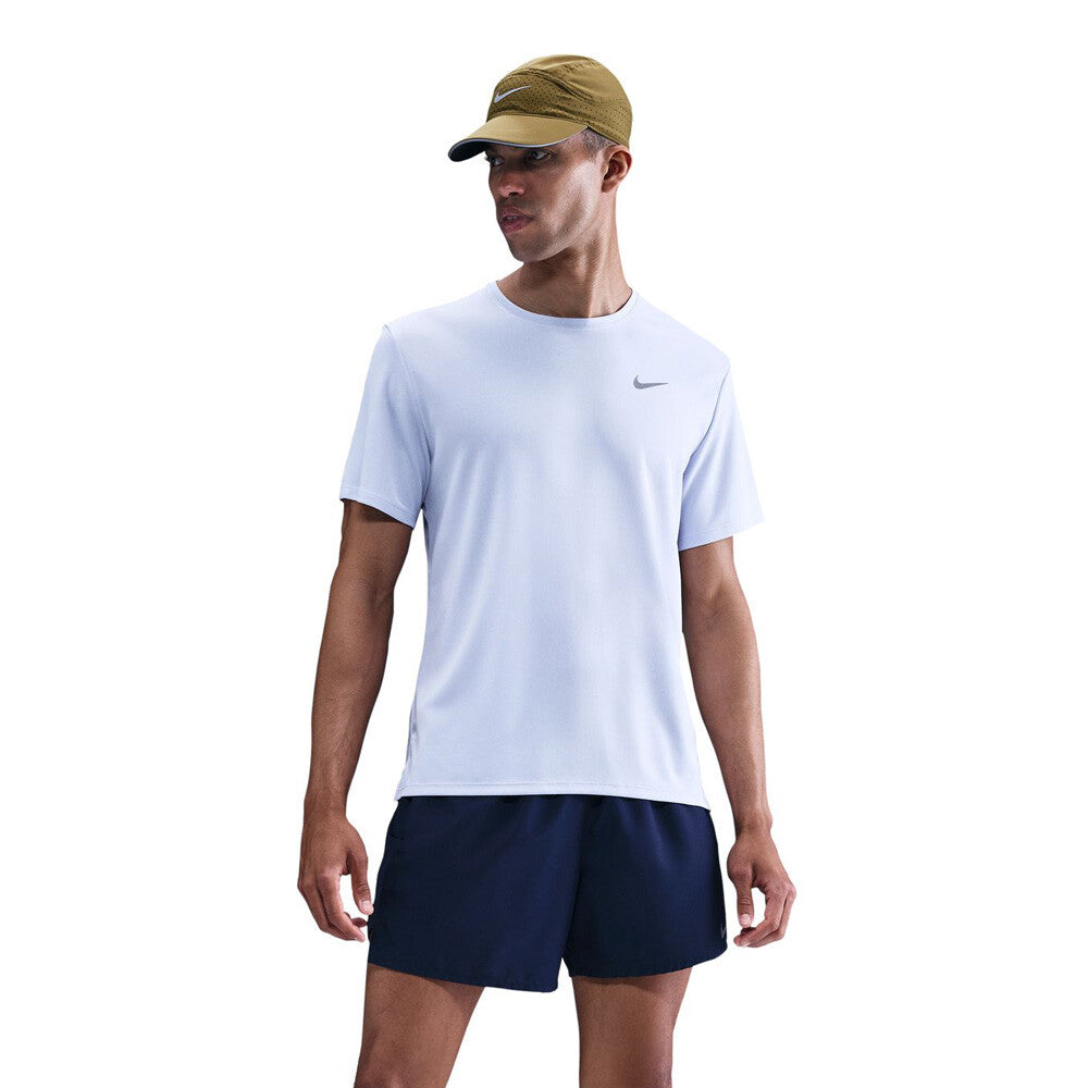 Man wearing a light blue Nike t-shirt and navy shorts on a white background