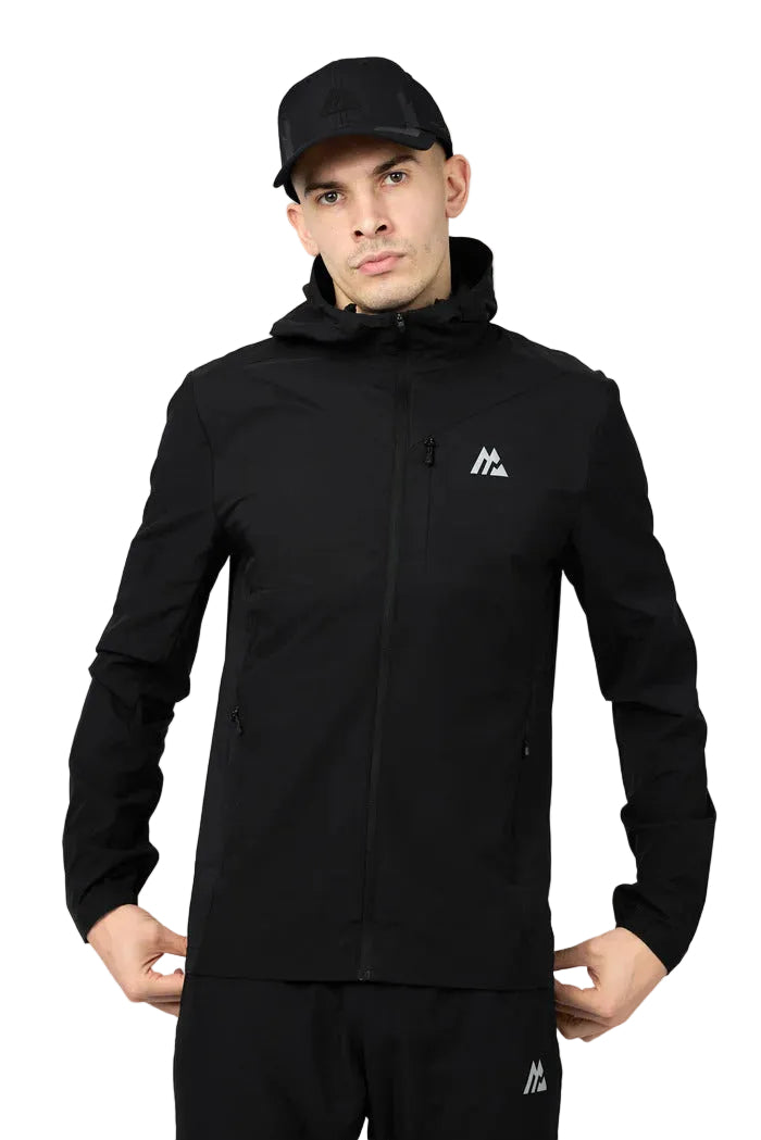 Man wearing a black jacket and cap on a gray background